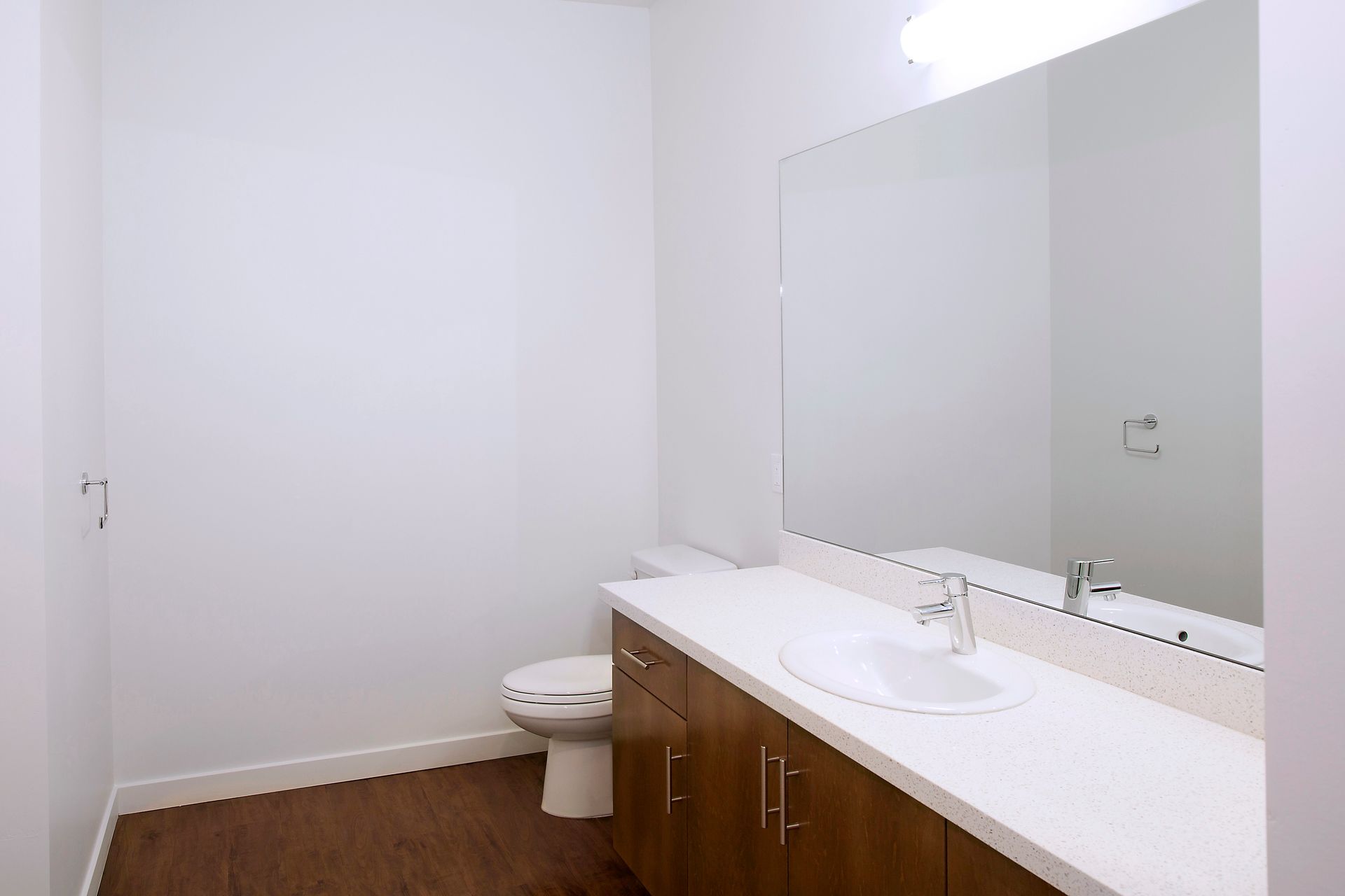 A bathroom with a toilet , sink , and mirror.