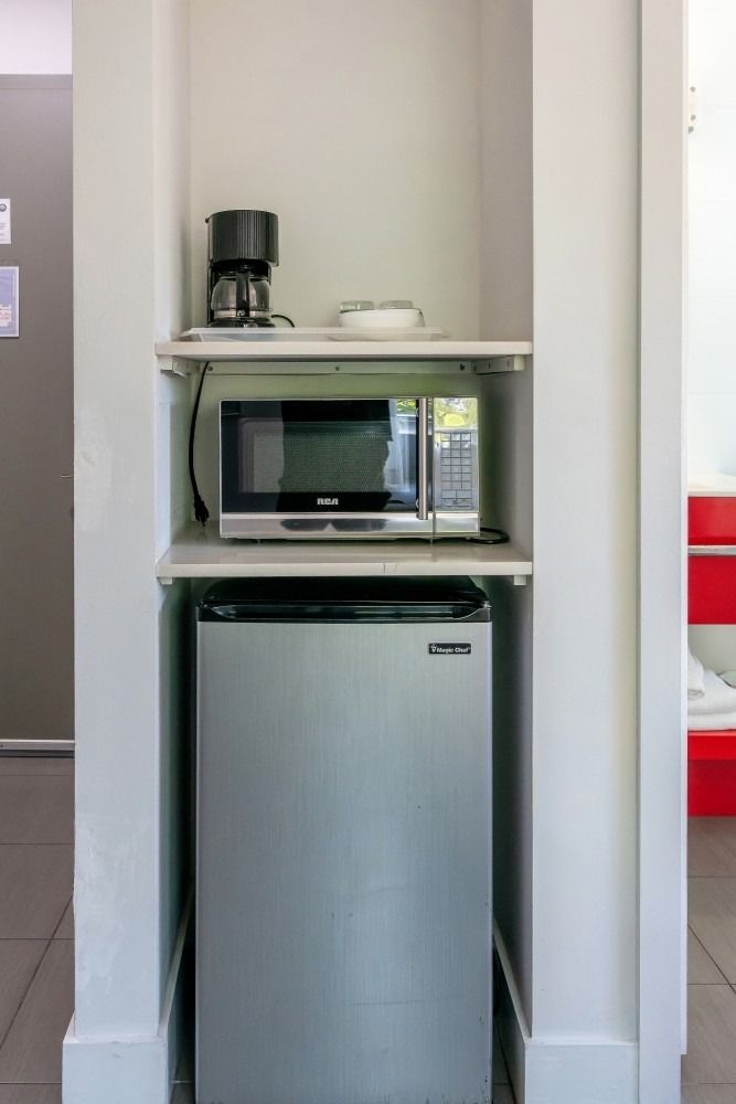 Built-in kitchenette: microwave, mini-fridge, coffee maker on shelves in a white alcove.