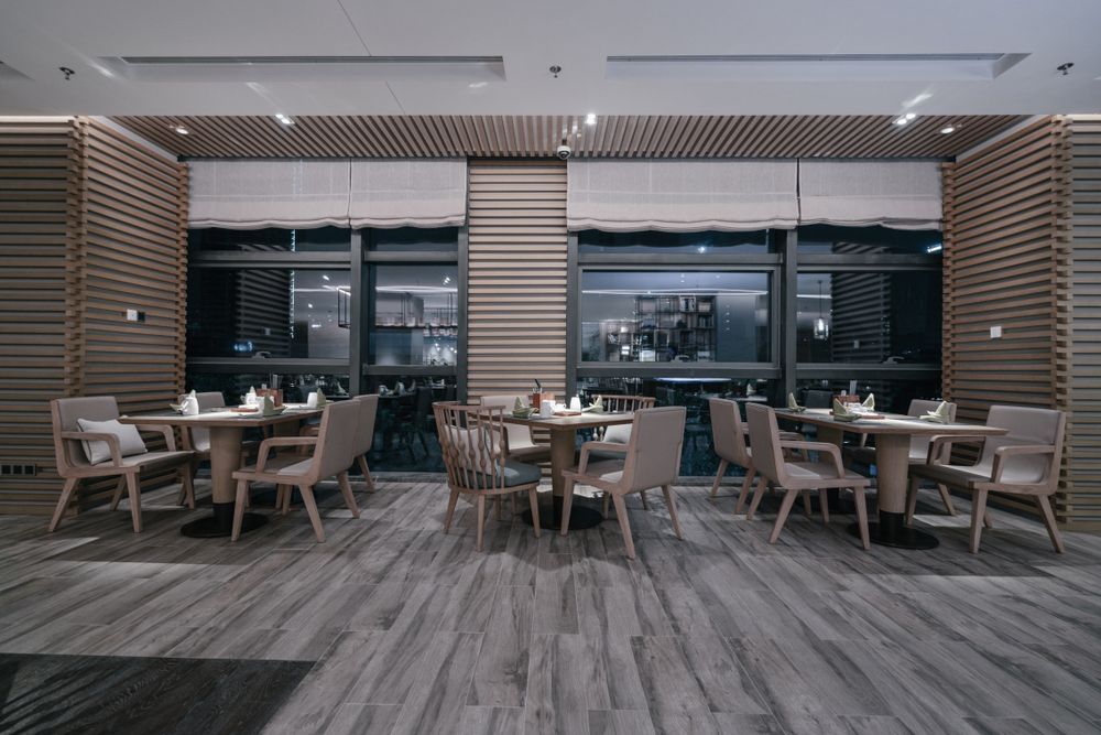 A restaurant with tables and chairs and a wooden floor