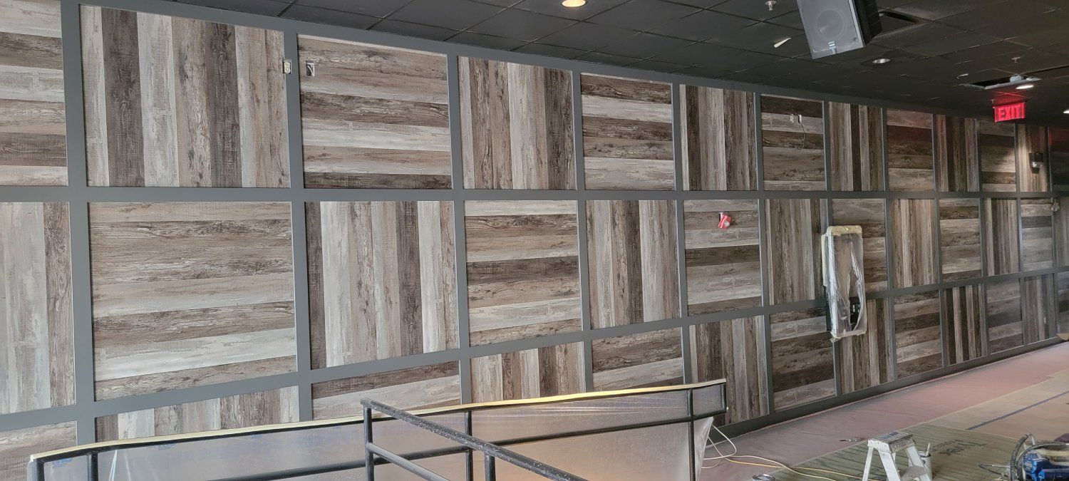 A room with a wooden wall and a red exit sign