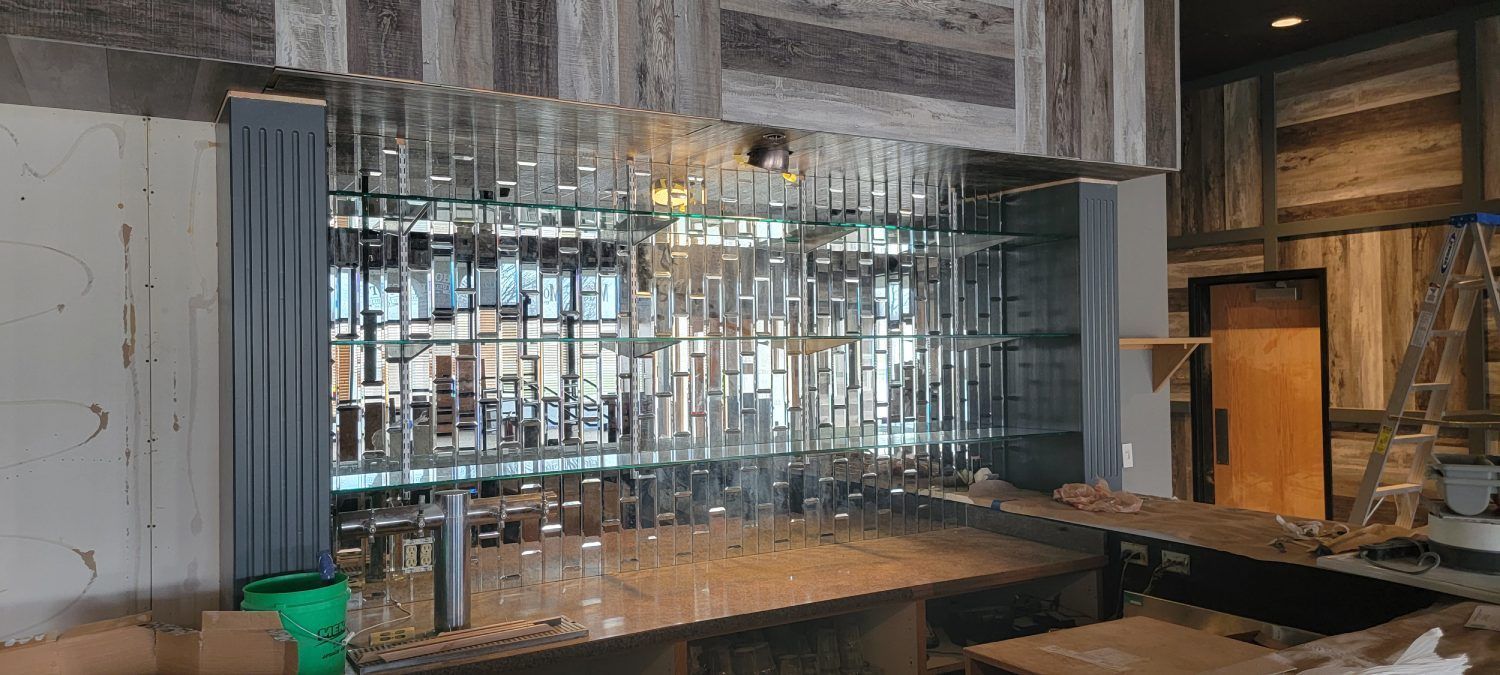 A bar with a lot of glasses on it is being built in a building