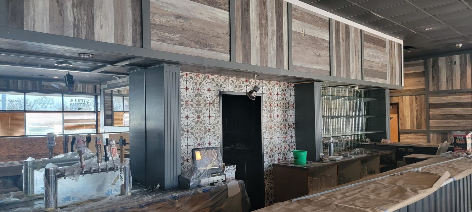 An empty restaurant with wooden walls and a bar