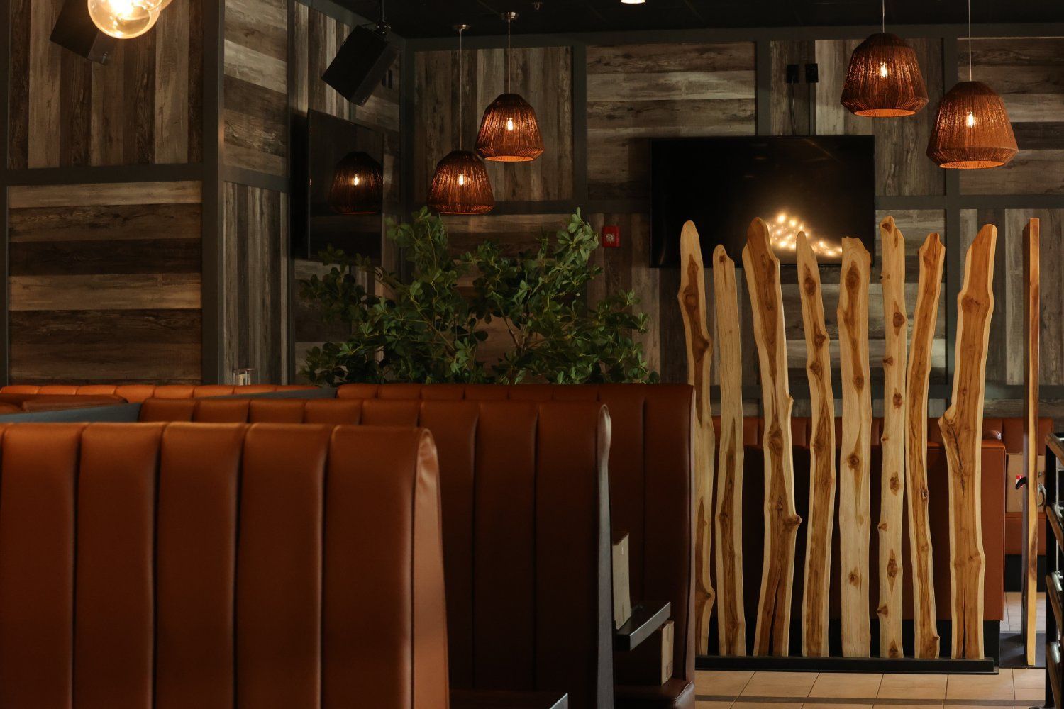 A restaurant with a wooden divider between two booths.