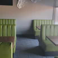 A restaurant with green booths and tables