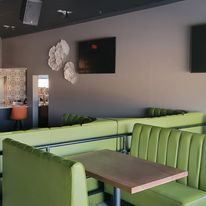 A restaurant with green benches and tables