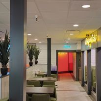 A restaurant with tables and chairs in a hallway