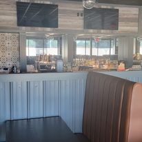 The inside of a restaurant with a bar and a booth