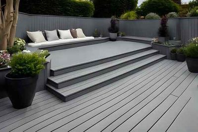 A composite deck with stairs leading up to it and a bench.