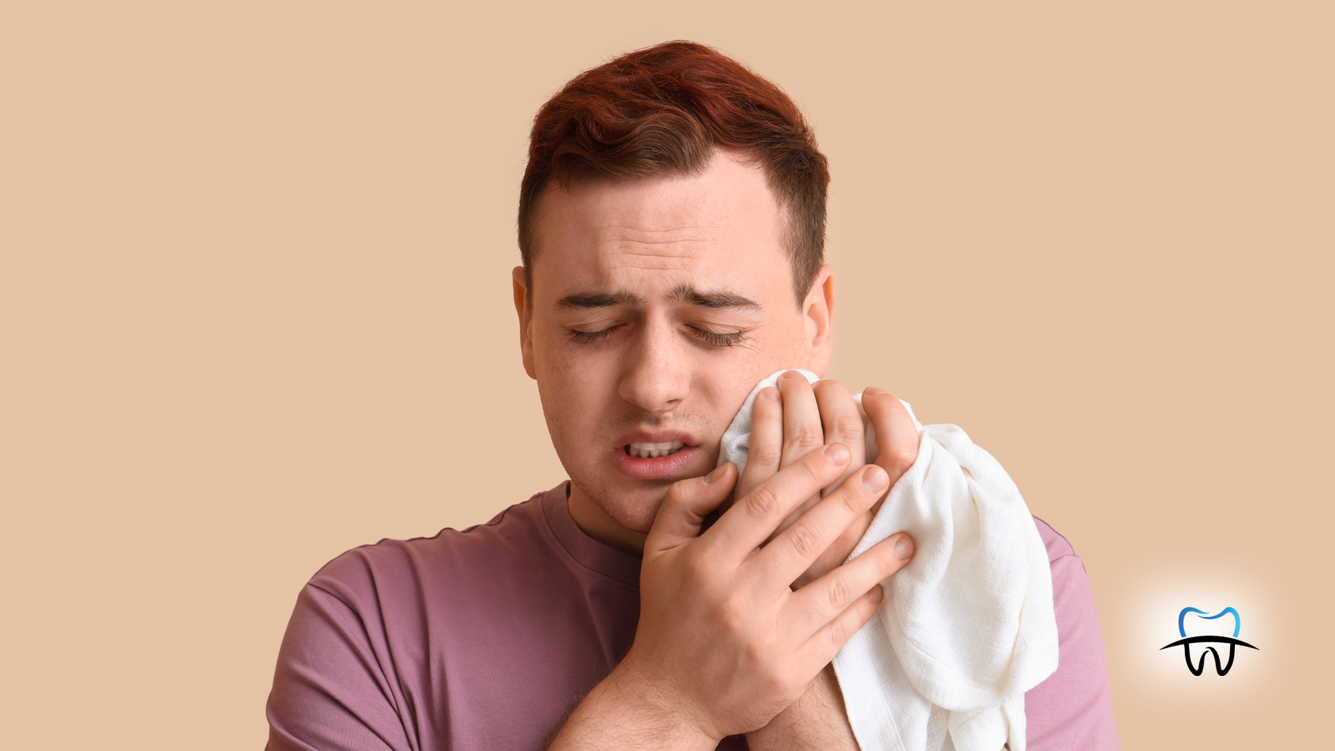 Man with pained expression holding a cloth to his cheek, likely due to a toothache.