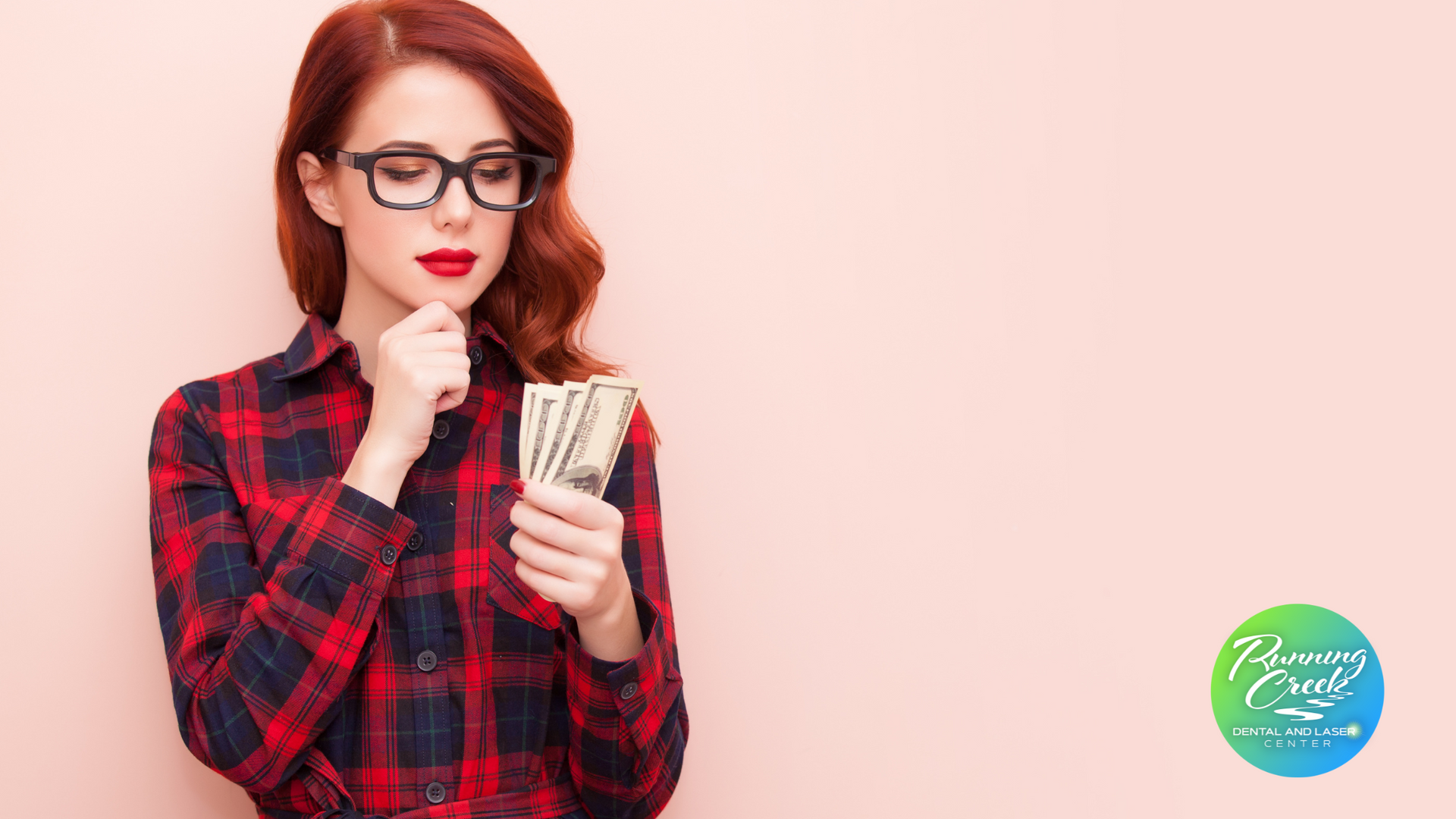 A woman wearing glasses is holding a bunch of money in her hand.