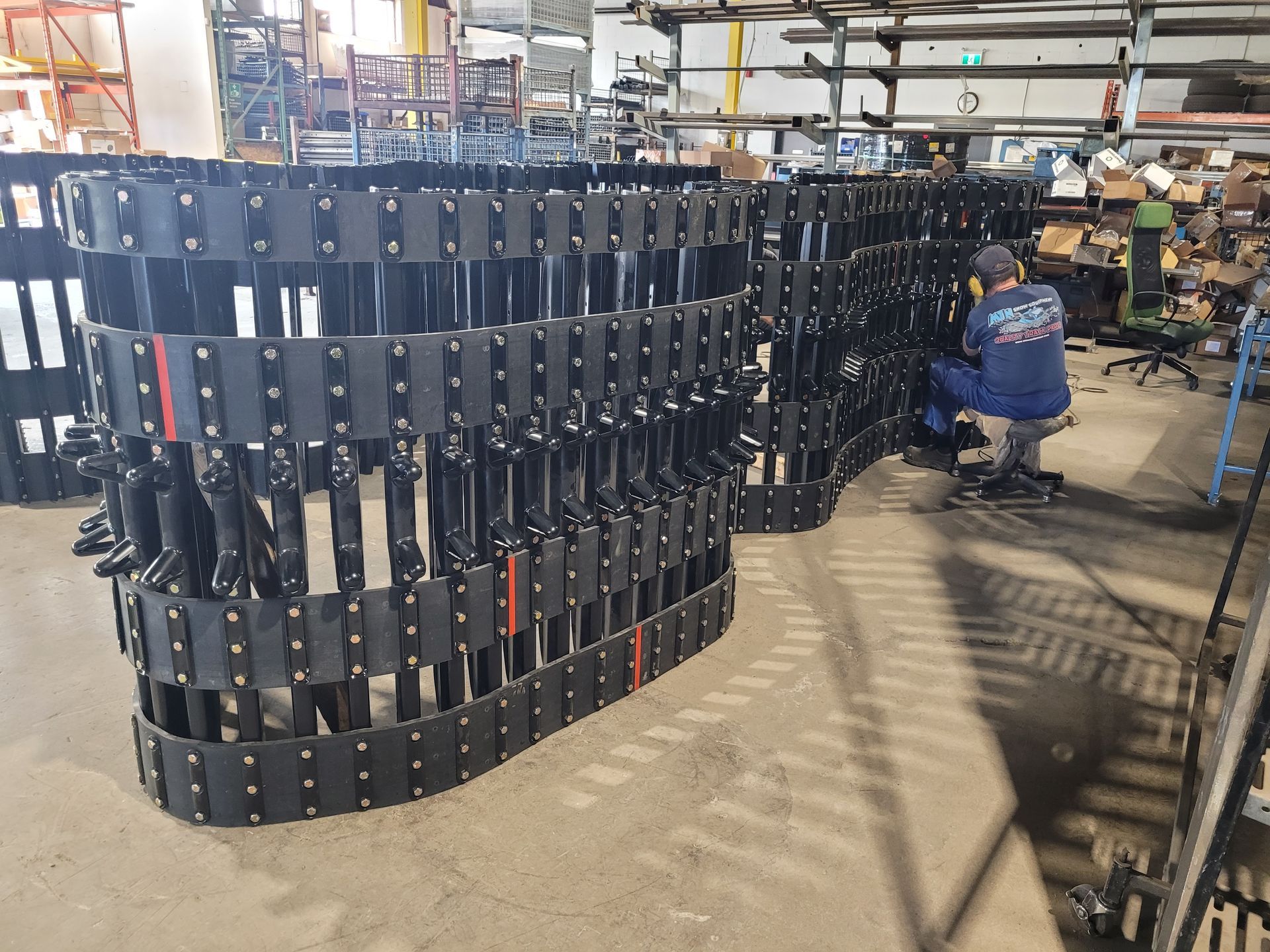 A man is working on a row of tracks in a factory.