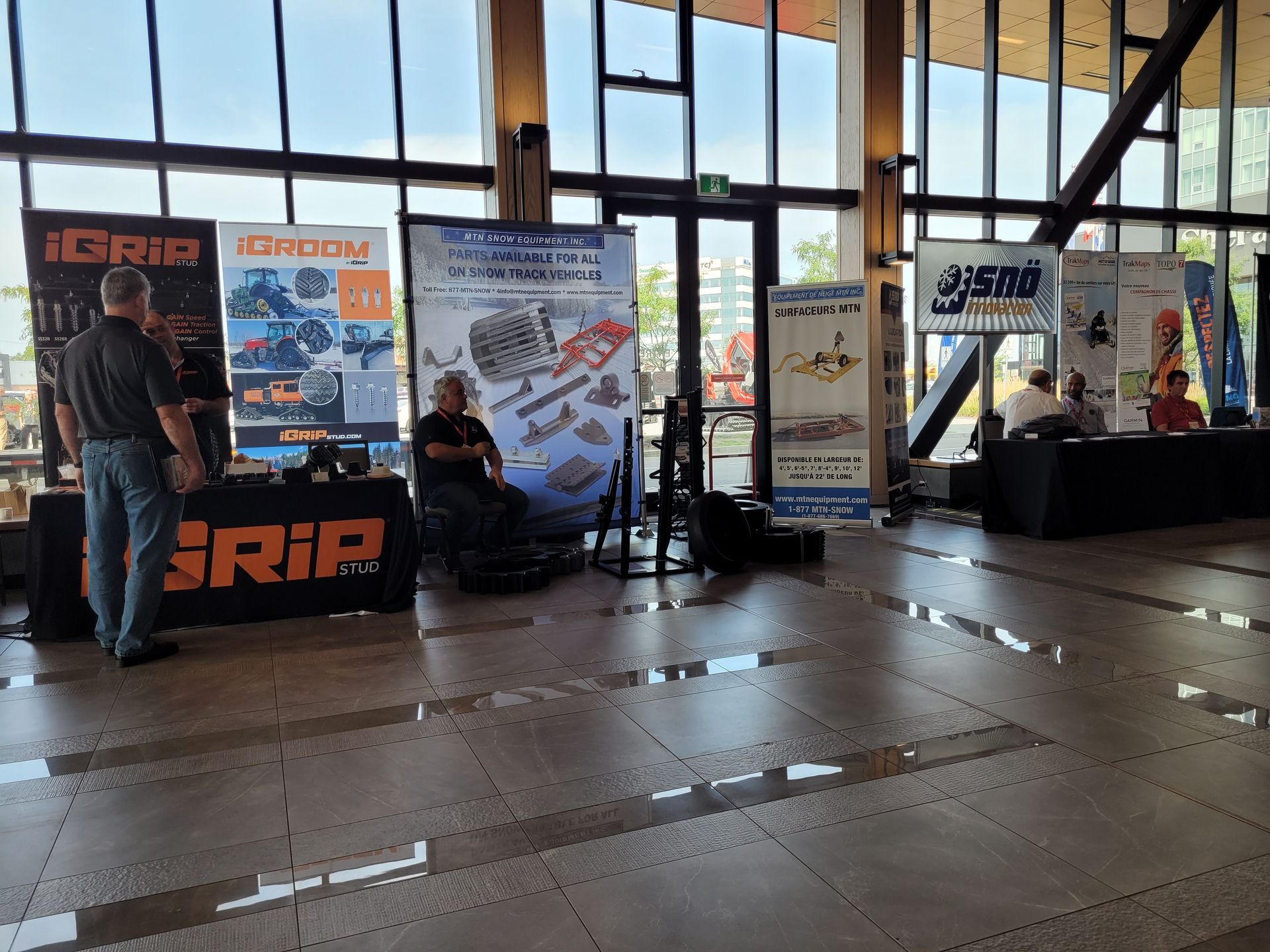 A man is sitting at a table in front of a sign that says grip.