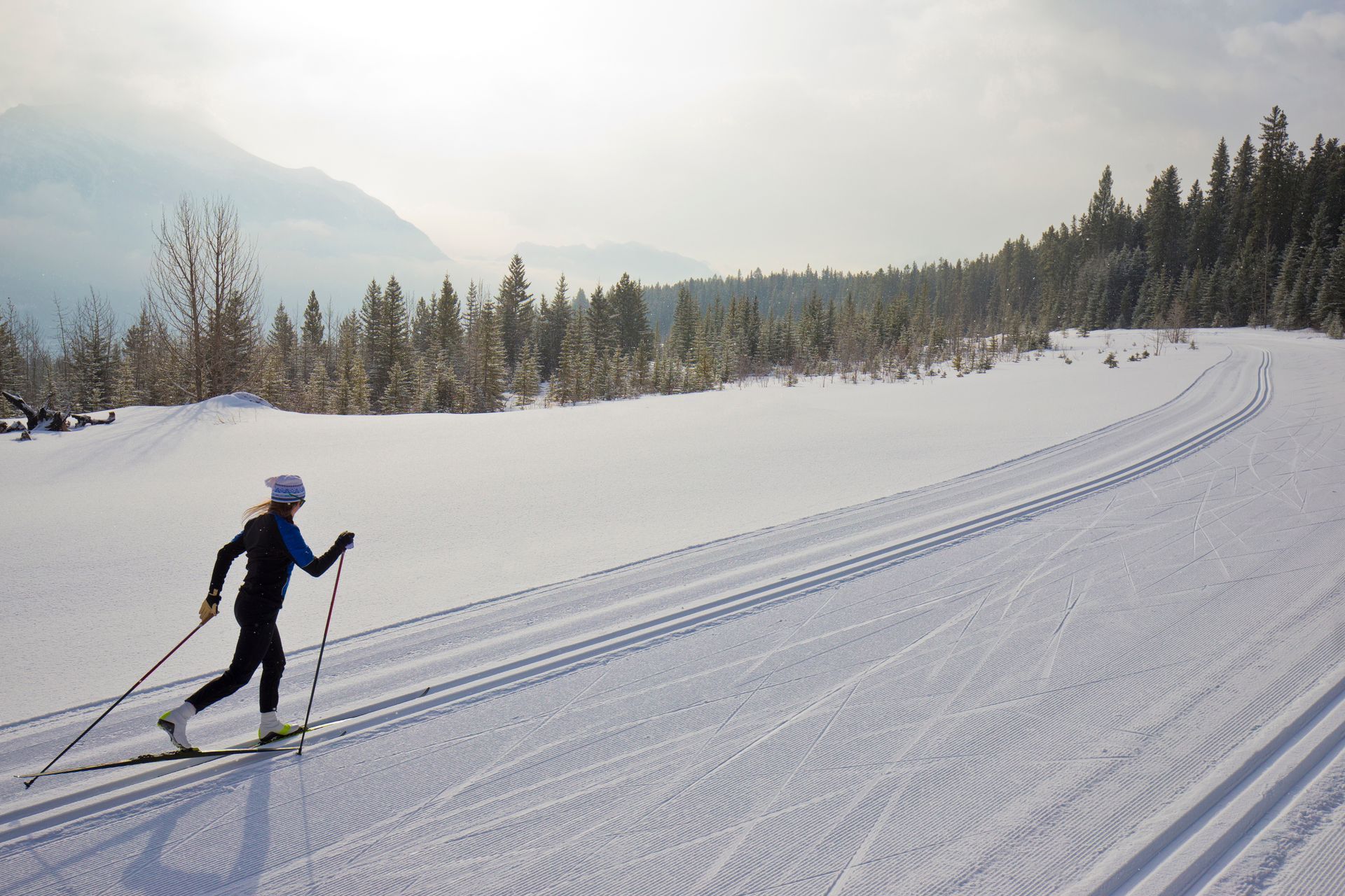 A person is cross country skiing on a snowy slope.