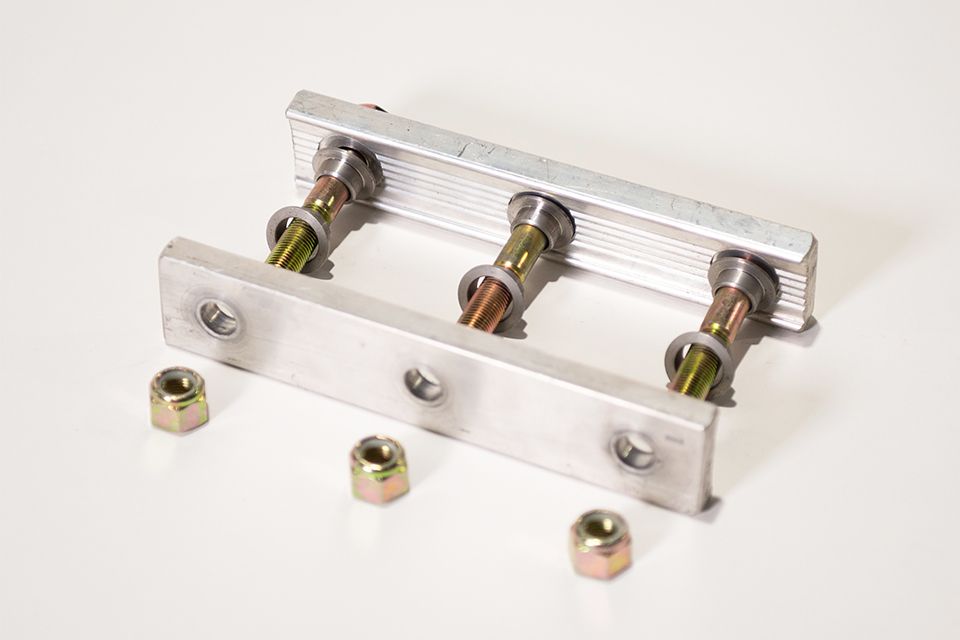 A metal bracket with nuts and bolts on a white surface.