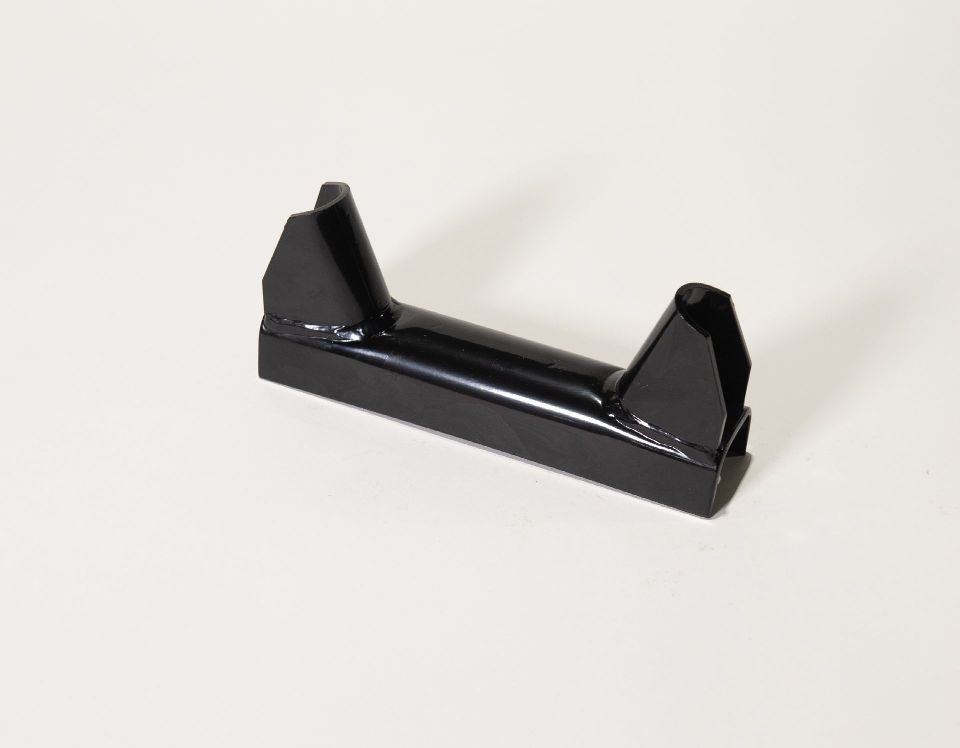 A black piece of metal is sitting on a white surface.