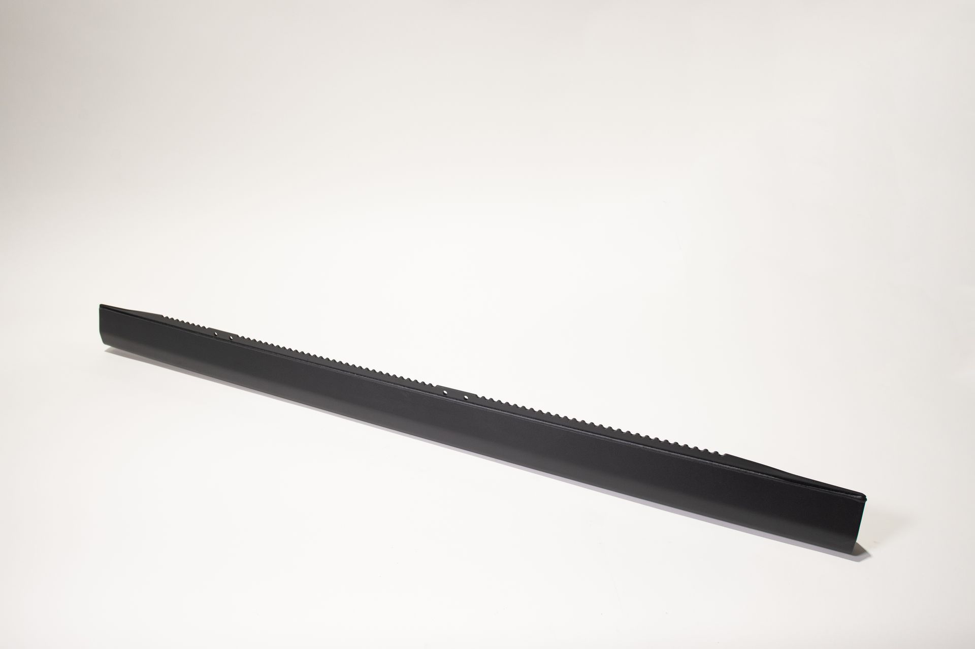A long black object is sitting on a white surface.