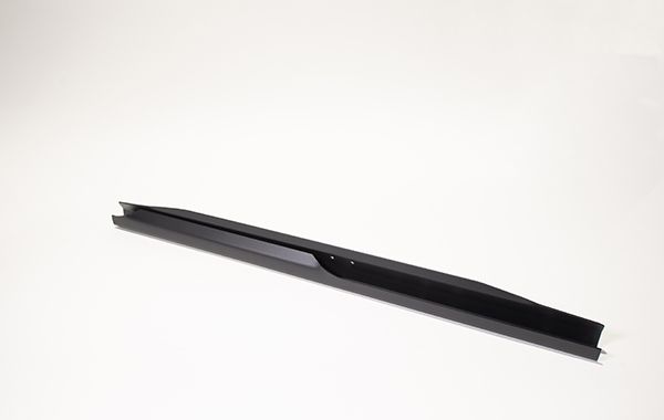 A black pen is sitting on a white surface.