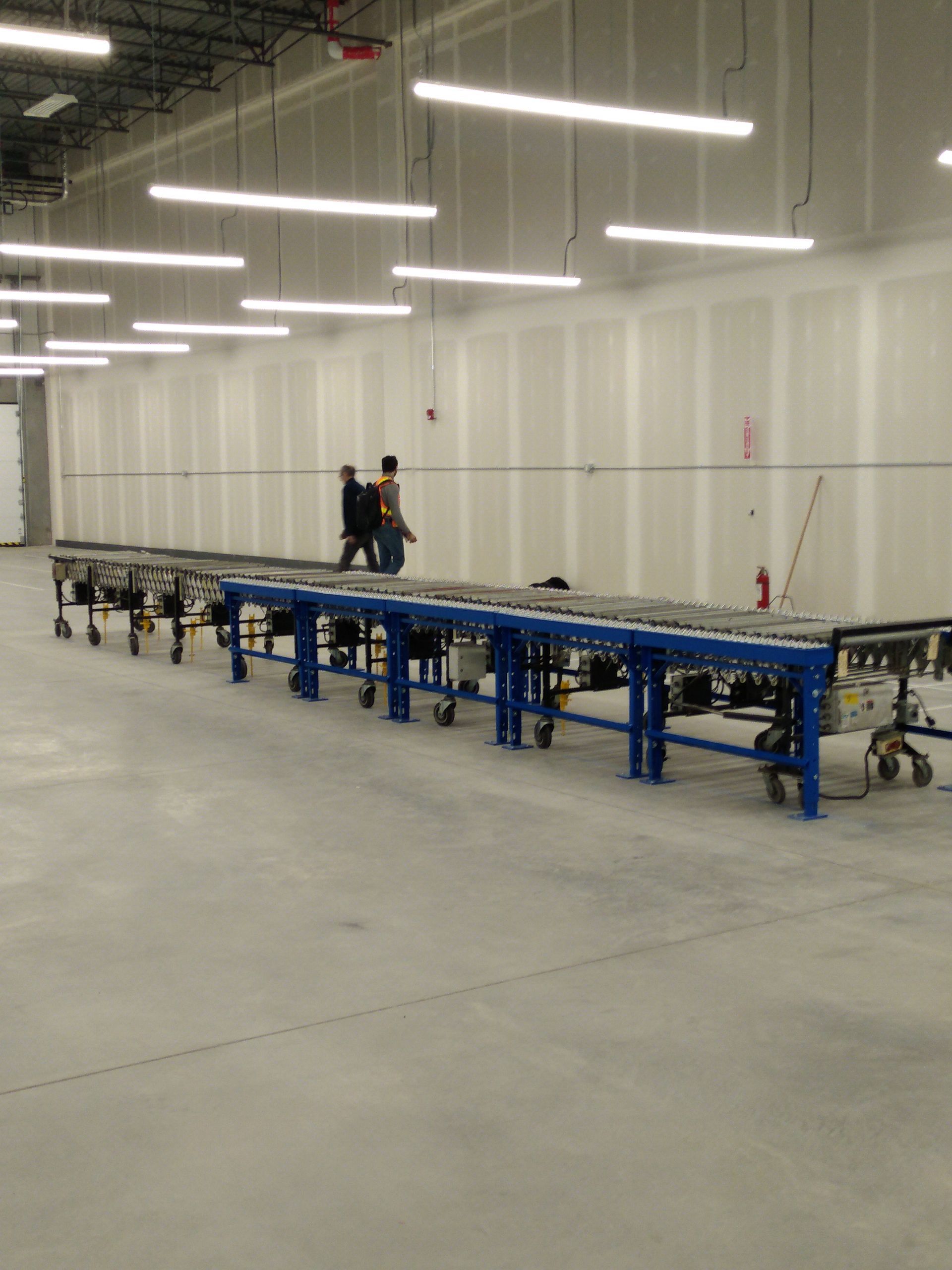 A warehouse with a long conveyor belt in the middle