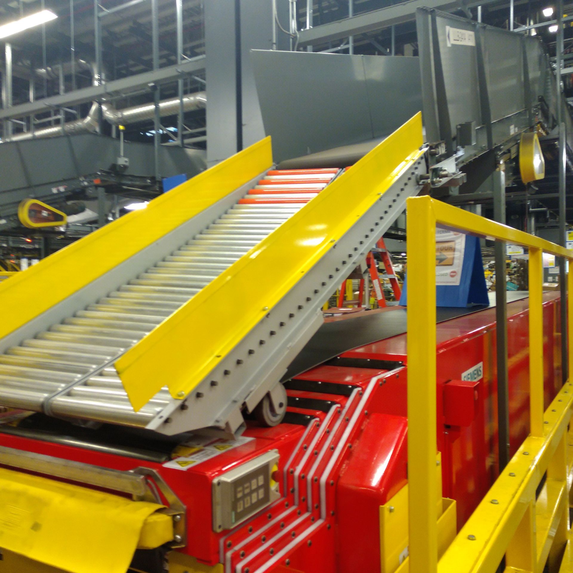 A conveyor belt in a factory with a yellow ramp