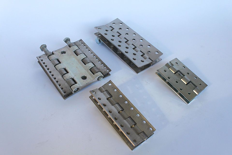Four different types of hinges are sitting on a white surface