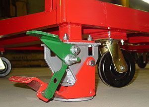 A close up of a red cart with wheels and a green handle.