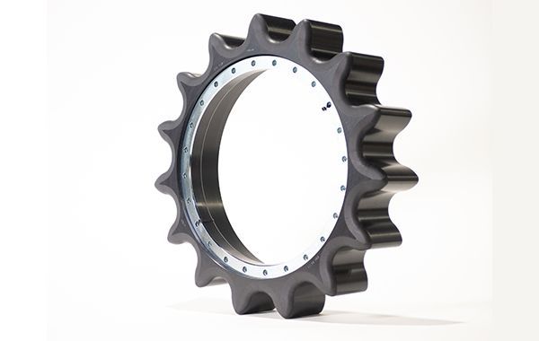 A close up of a black gear on a white surface.