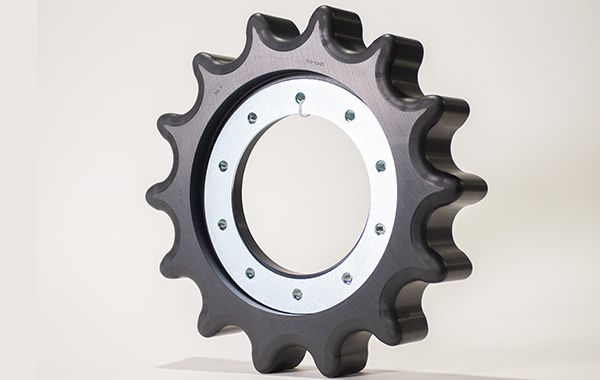 A close up of a black gear on a white surface.