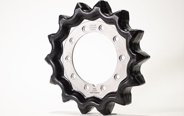 A black gear with holes in it is sitting on a white surface.