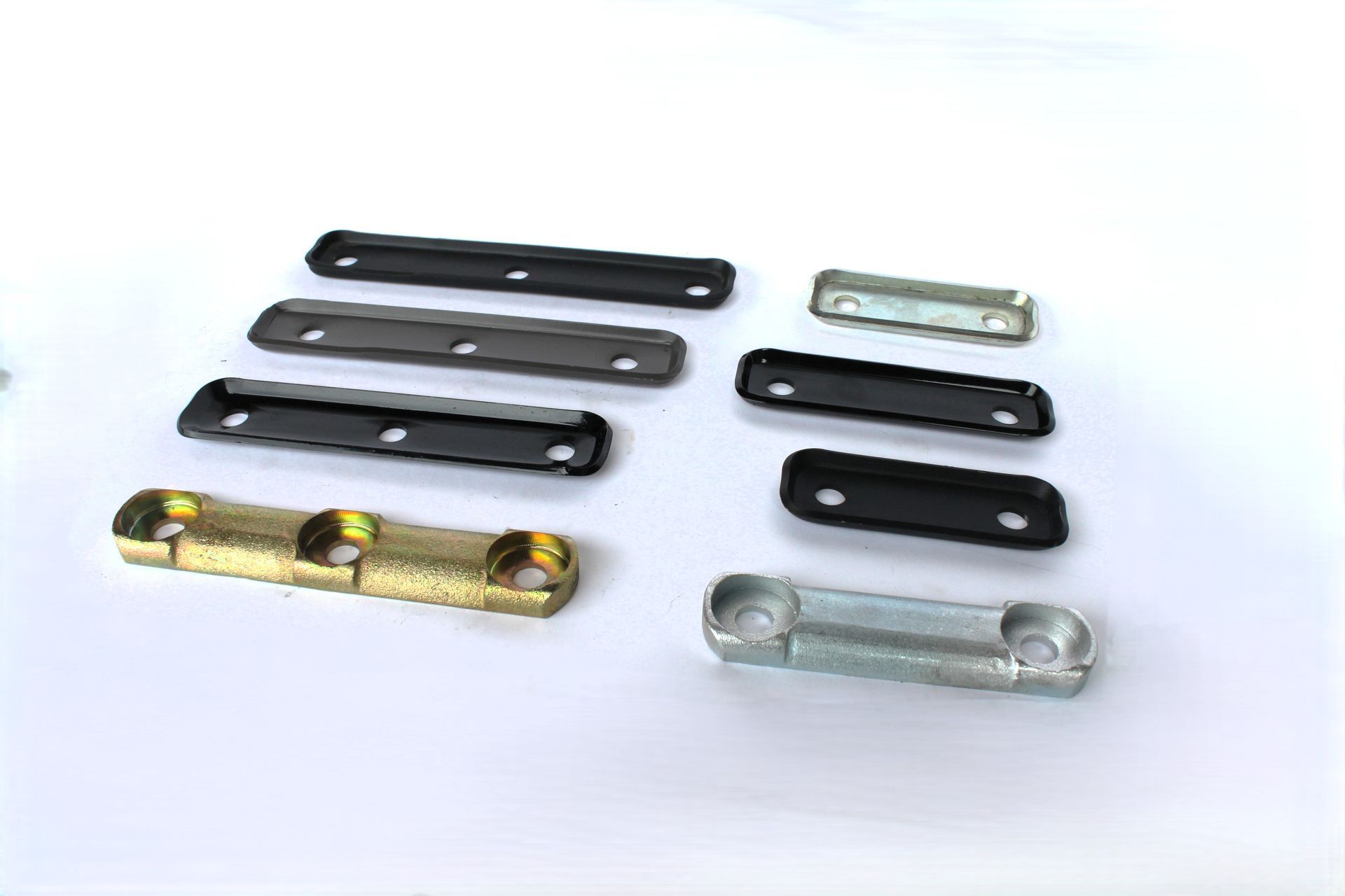 A bunch of metal pieces are sitting on top of each other on a white surface.