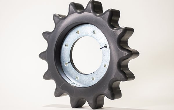 A close up of a black gear on a white surface.