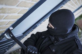 burglar breaking into door with crowbar