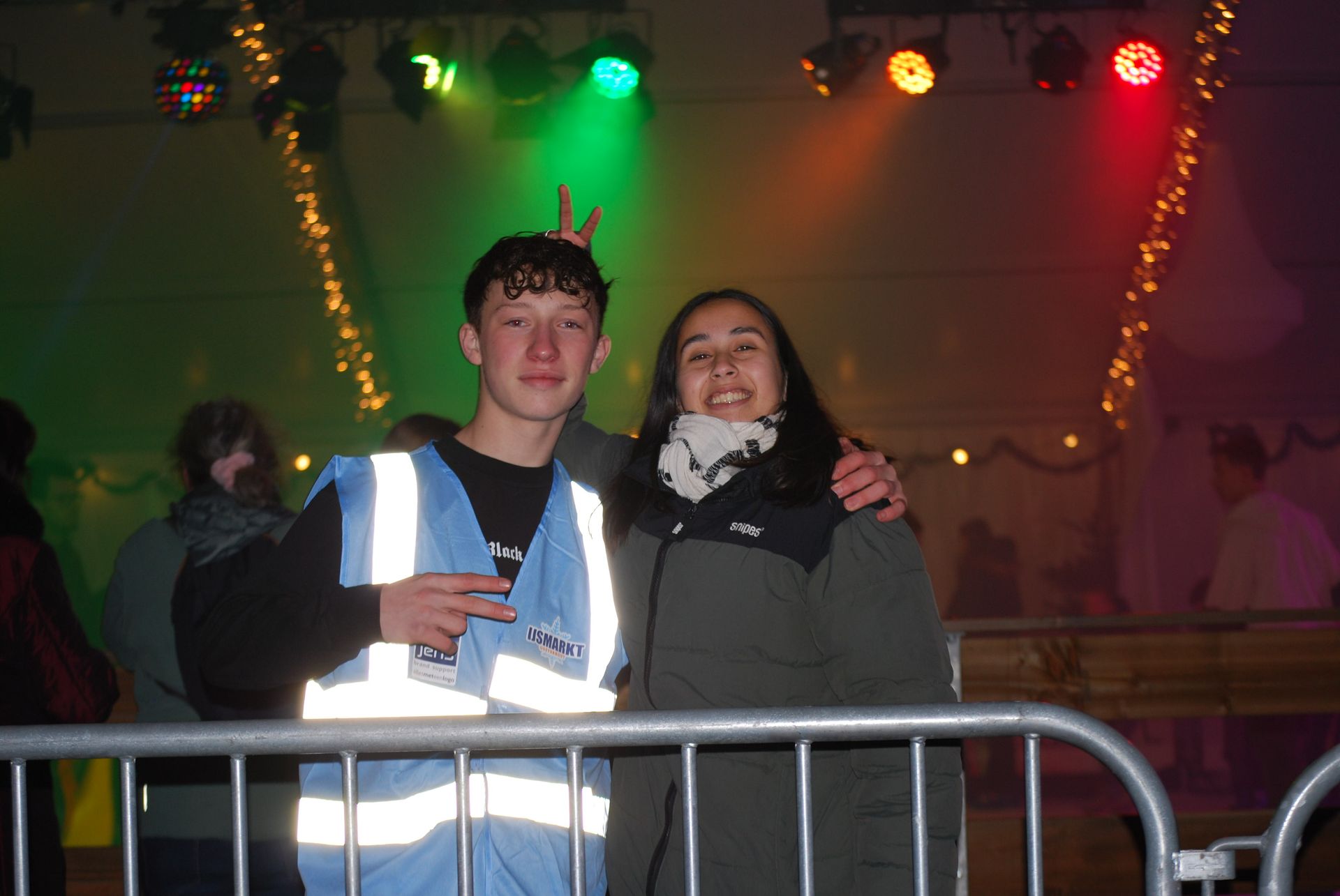 Een man en een vrouw poseren voor een foto achter een hek.