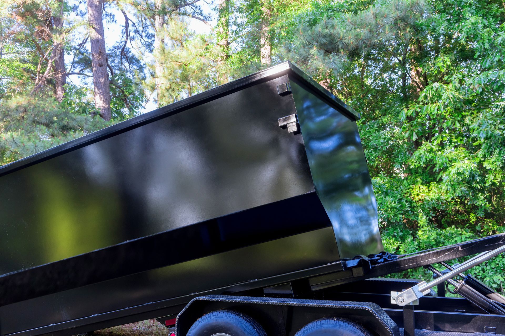 Loaded construction dumpster for rent with debris from home renovation project on residential site.