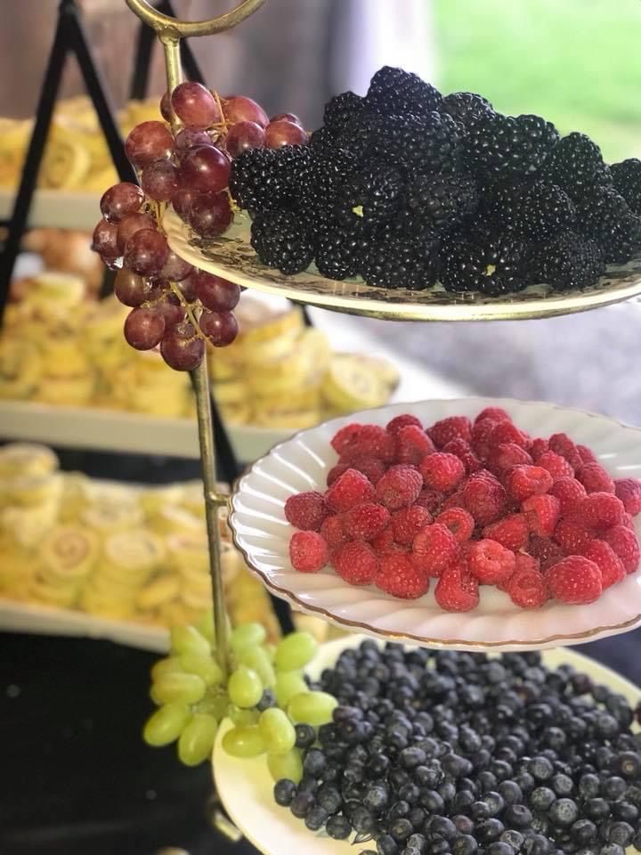 Tiered fruit display with blackberries, raspberries, blueberries, green grapes, and red grapes