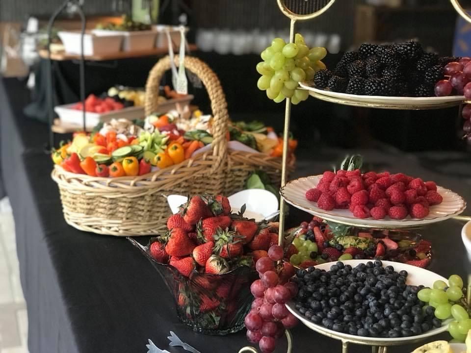 Assorted fresh fruit arranged on tiered trays and baskets at a market stand
