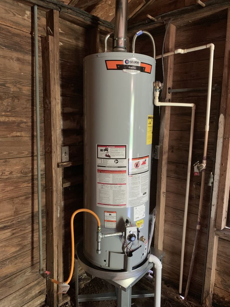 a gas water heater is sitting in a room next to a wooden wall .
