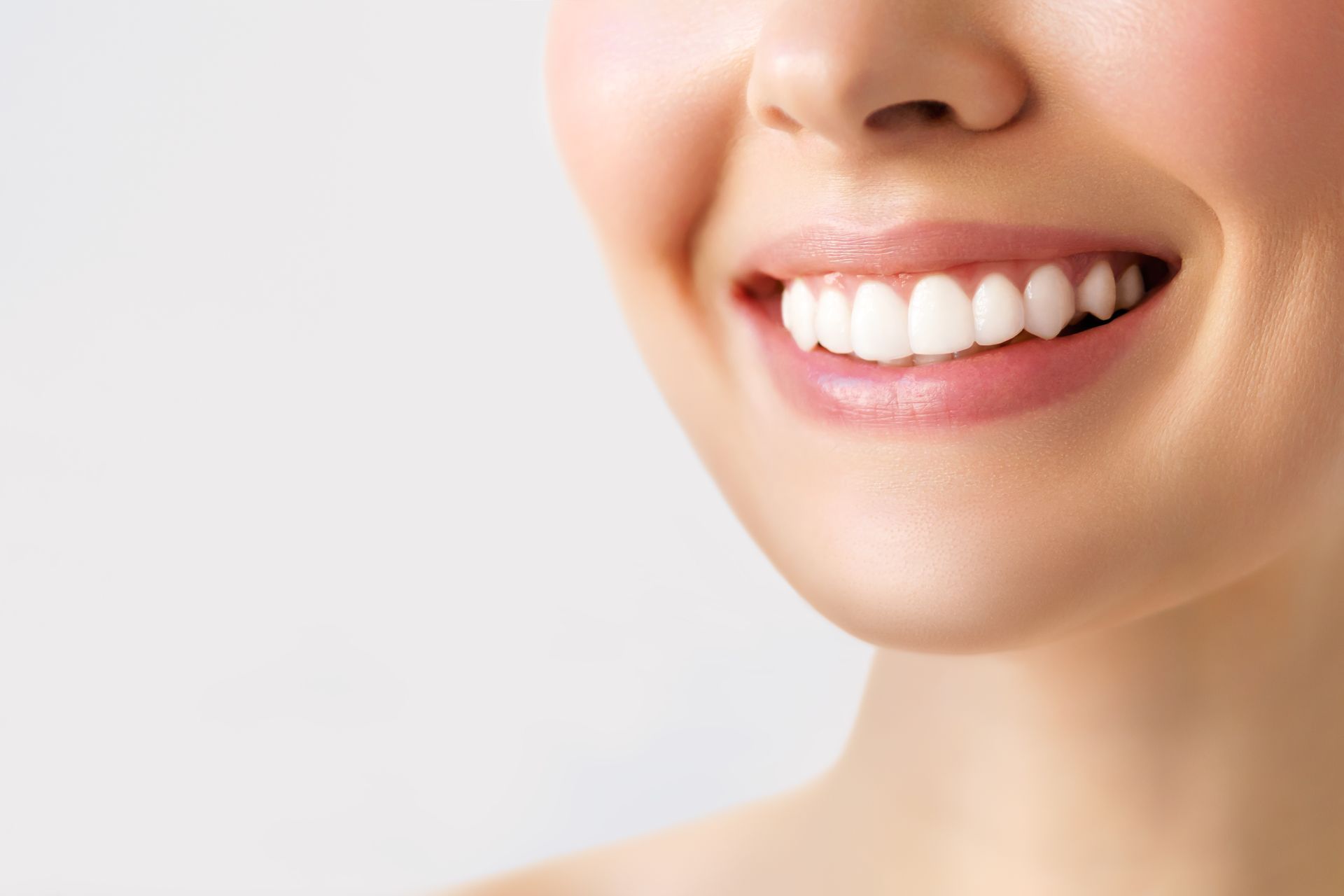 Close-up of a woman smiling with bright, healthy white teeth.