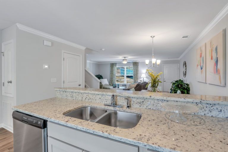 A kitchen with a sink , dishwasher , and granite counter tops.