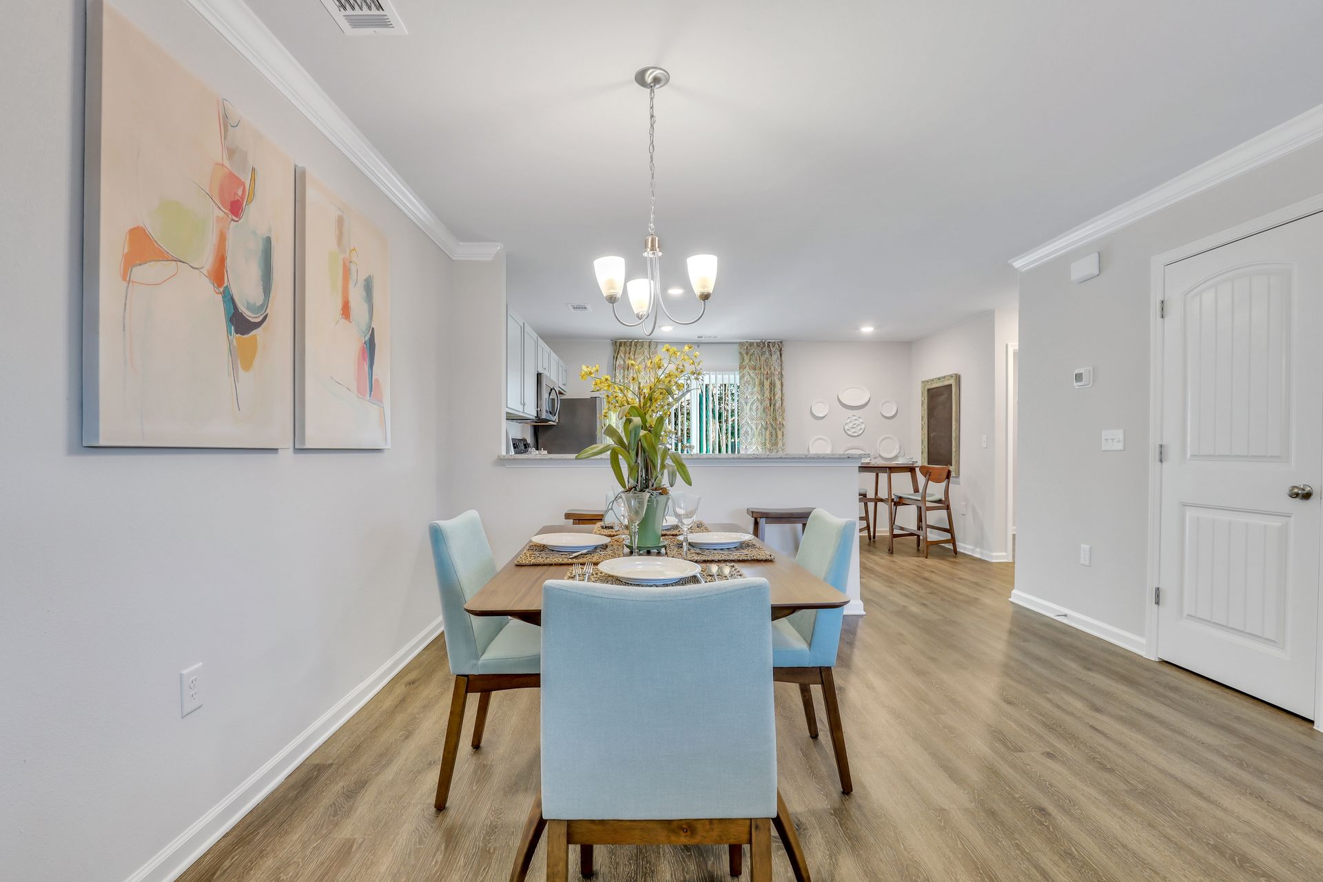 A dining room with a table and chairs and a chandelier.
