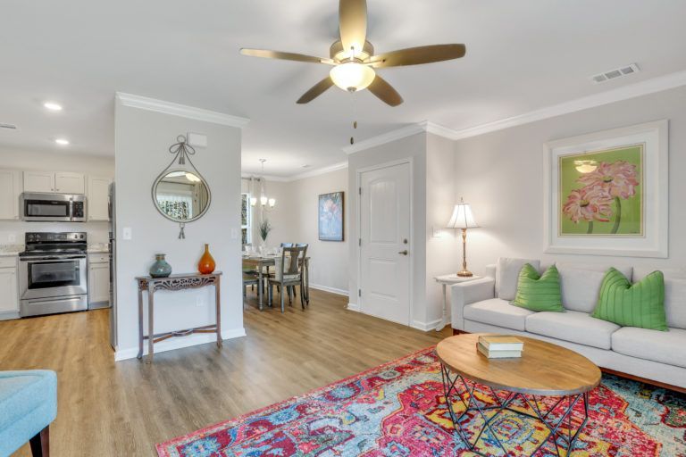 A living room with a couch , coffee table , and ceiling fan.
