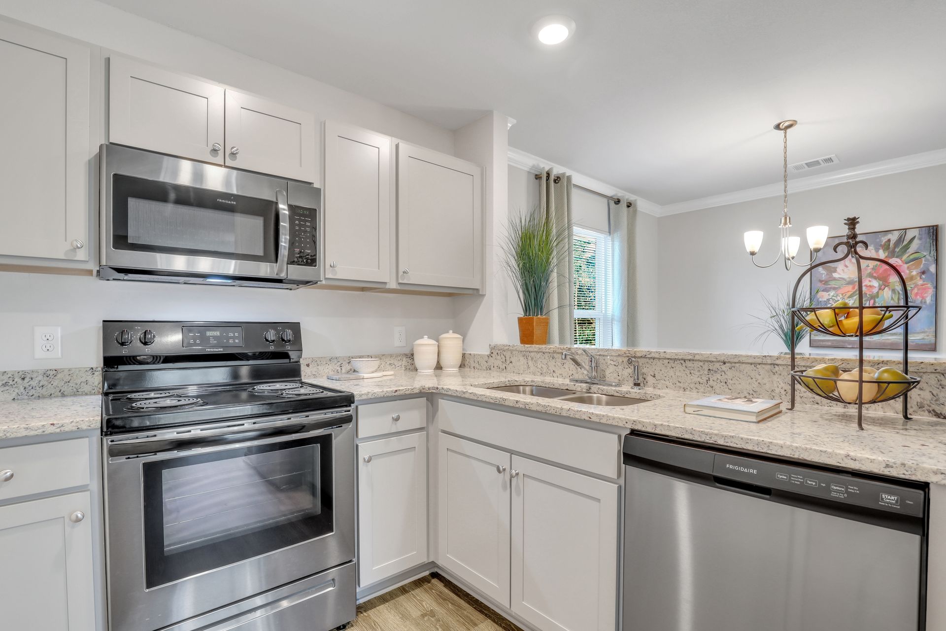 A kitchen with stainless steel appliances and white cabinets.