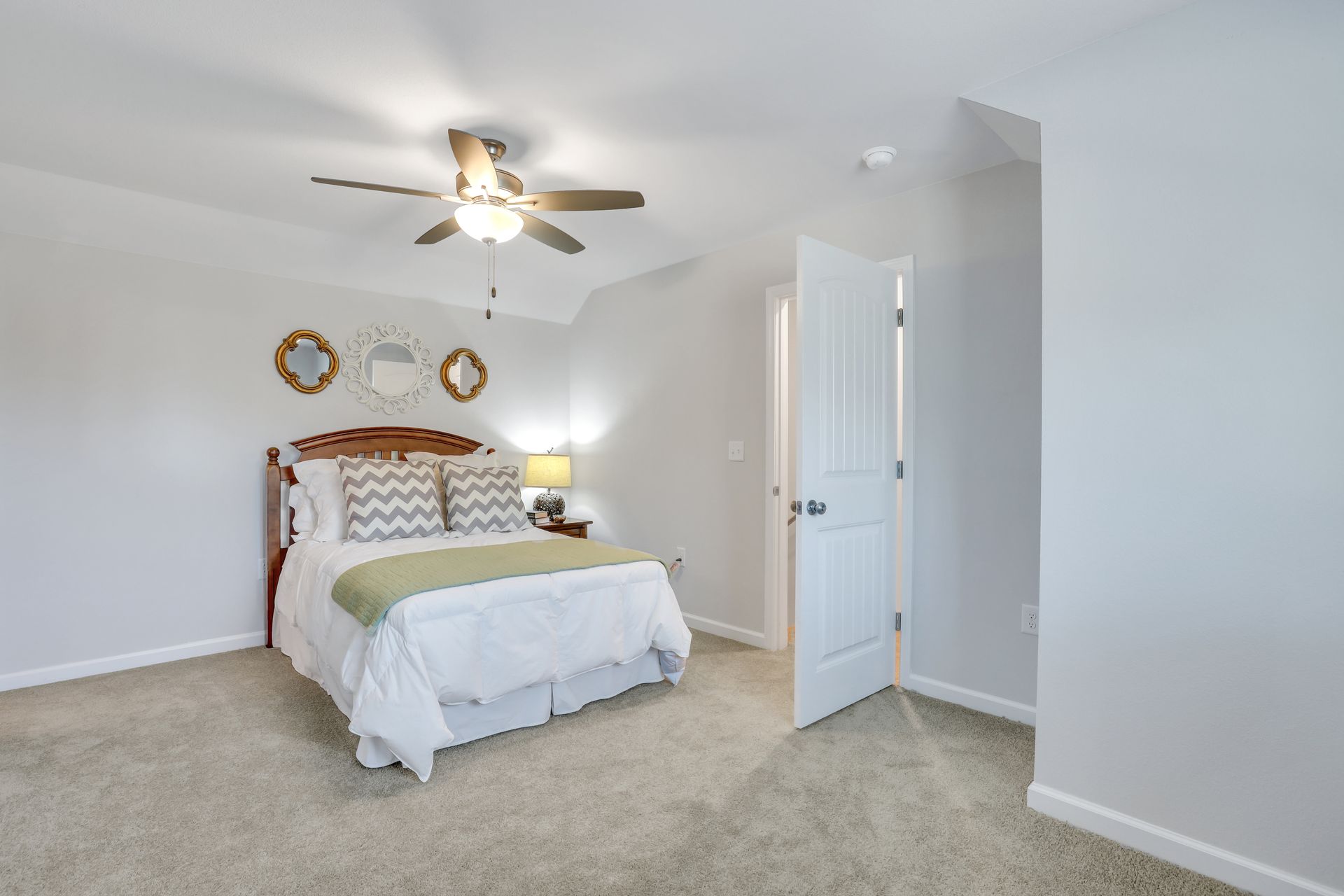 A bedroom with a bed and a ceiling fan.
