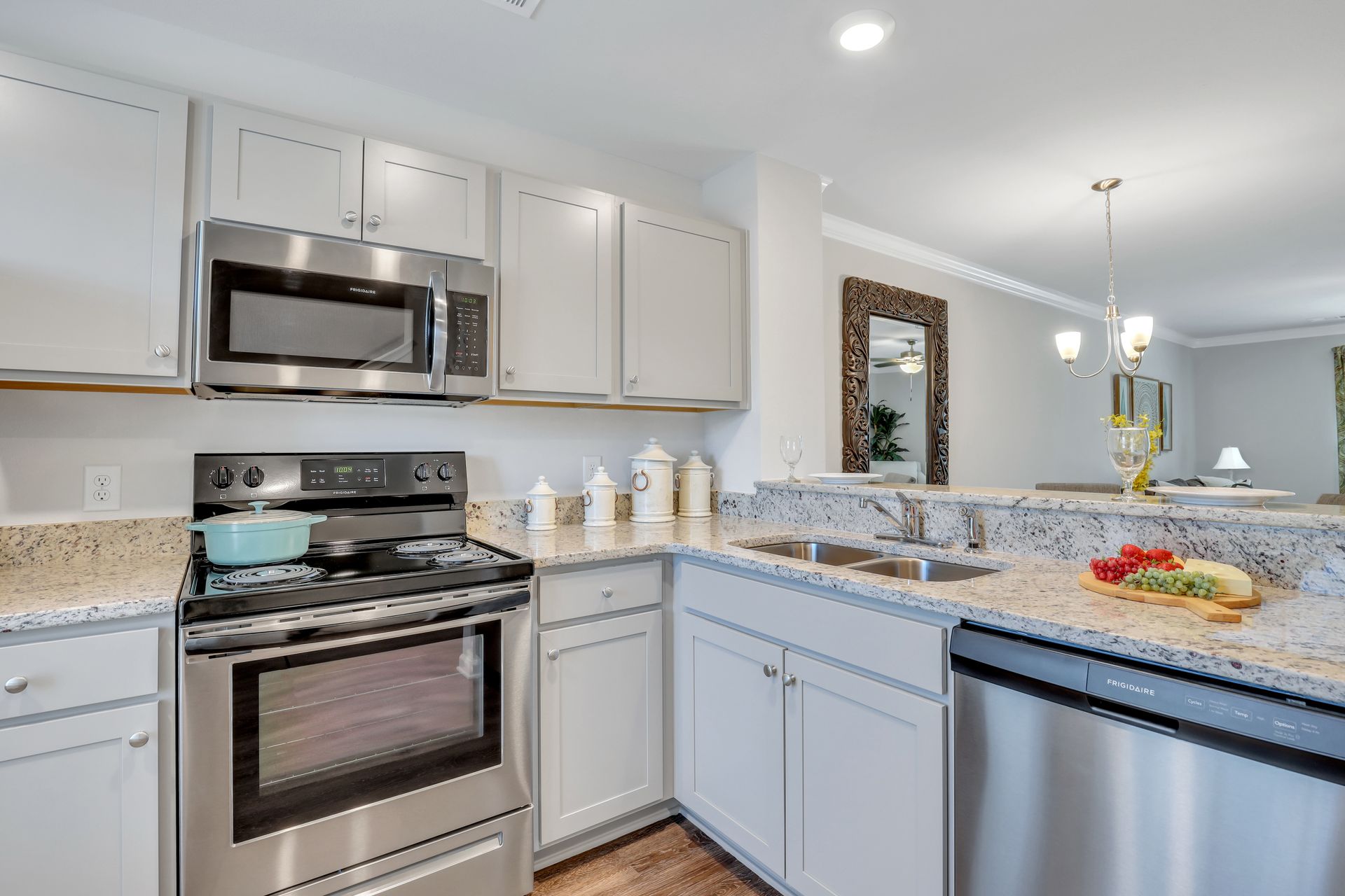 A kitchen with stainless steel appliances and white cabinets.