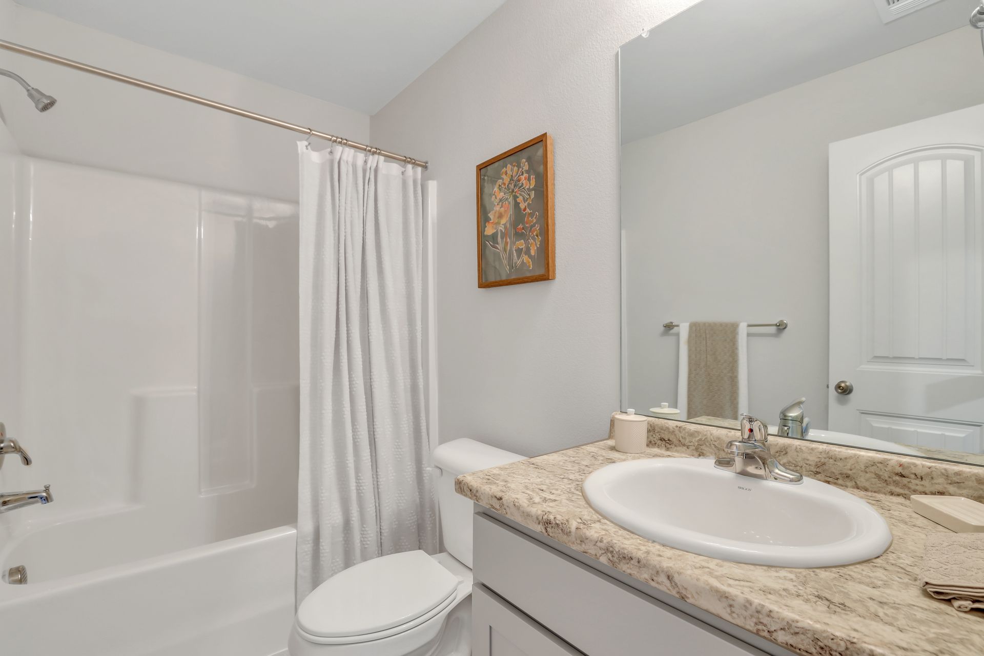 A bathroom with a toilet , sink , tub and shower.