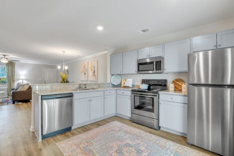 A kitchen with stainless steel appliances and white cabinets.
