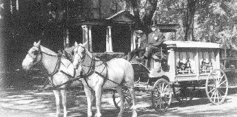 Black and white photo of horse drawn hearse for DeMoney-Grimes Funeral Home in Indiana