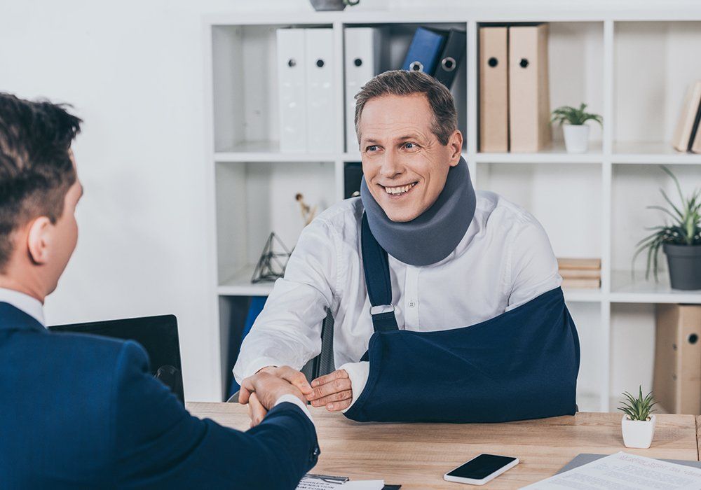 Worker in Neck Brace with Broken Arm and Businessman — Tukwila, WA — Law Offices of Daniel R. Whitmore, P.S.