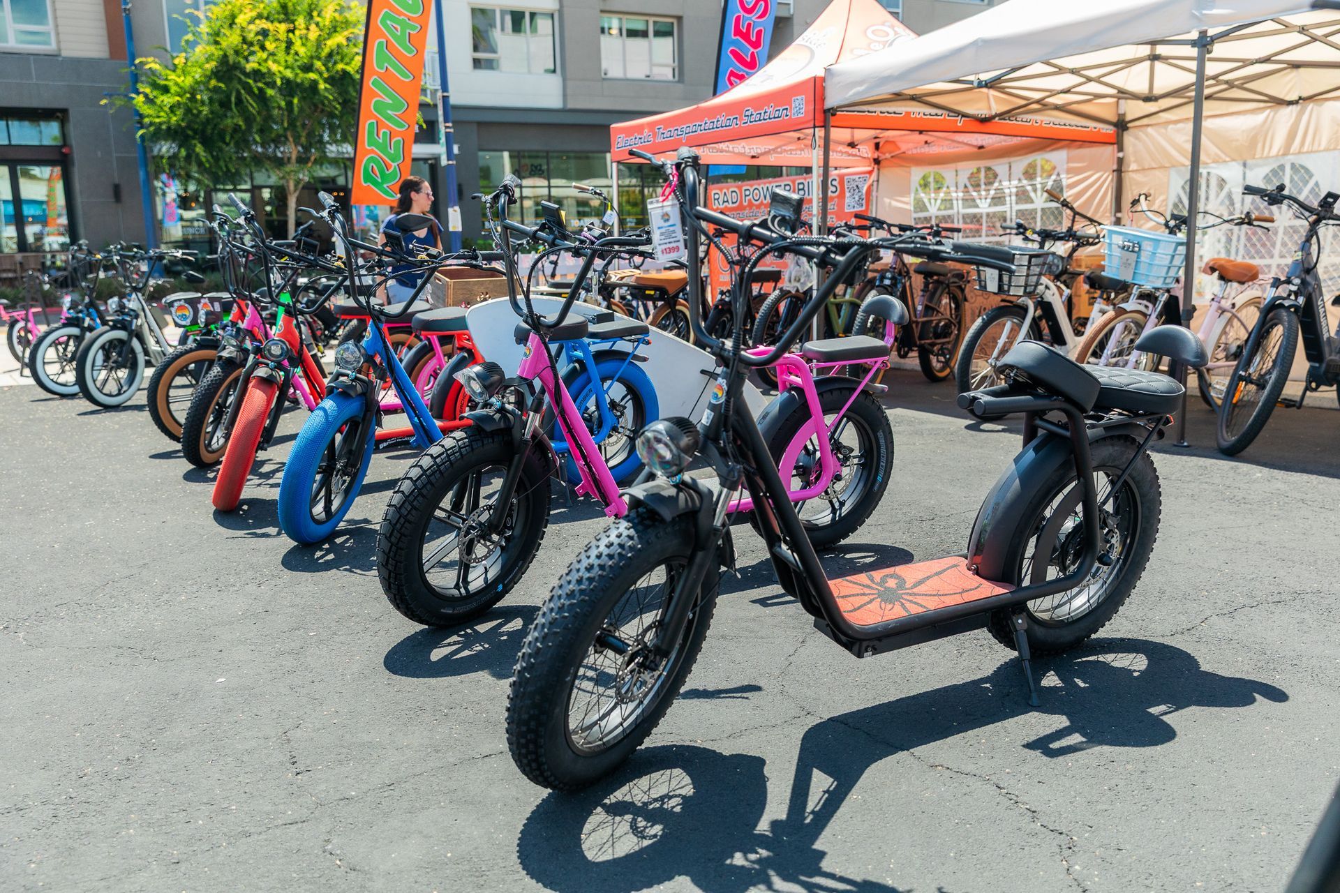A family of four is riding electric bikes in front of Ride Oside.