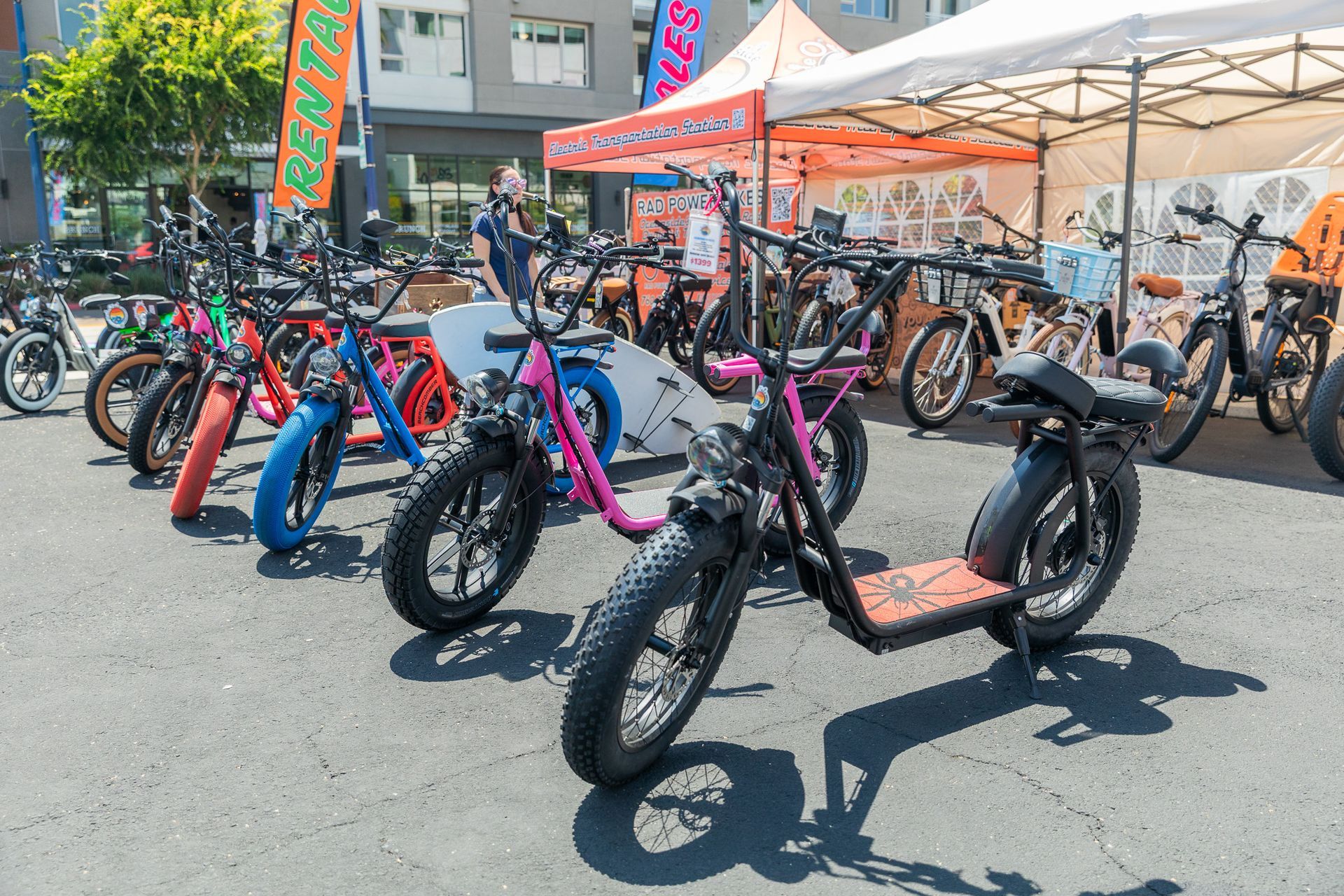 A row of electric scooters are parked on the sidewalk