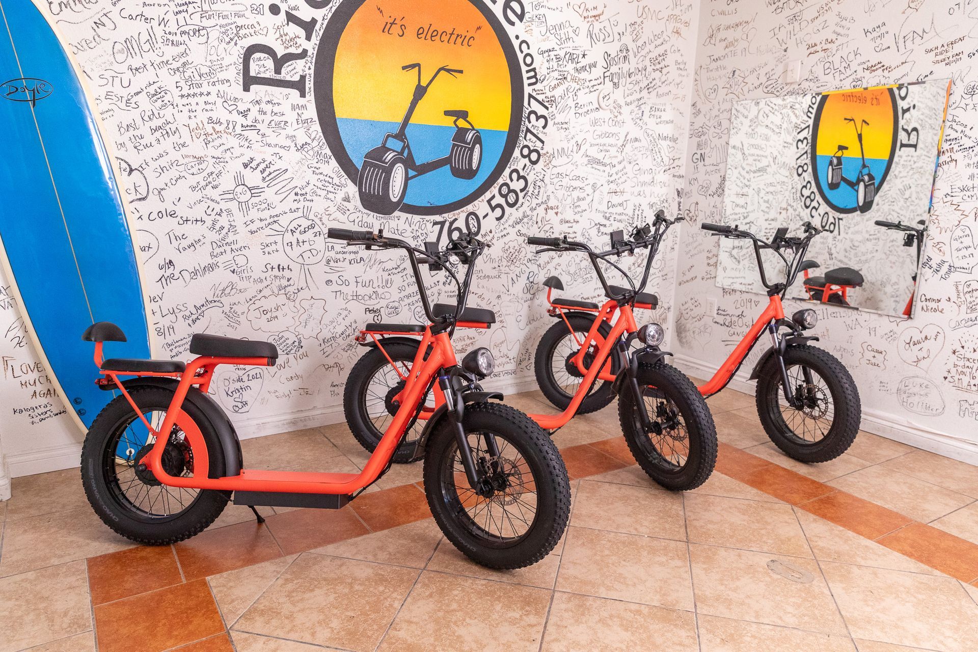 Three electric scooters are parked next to each other on the sidewalk